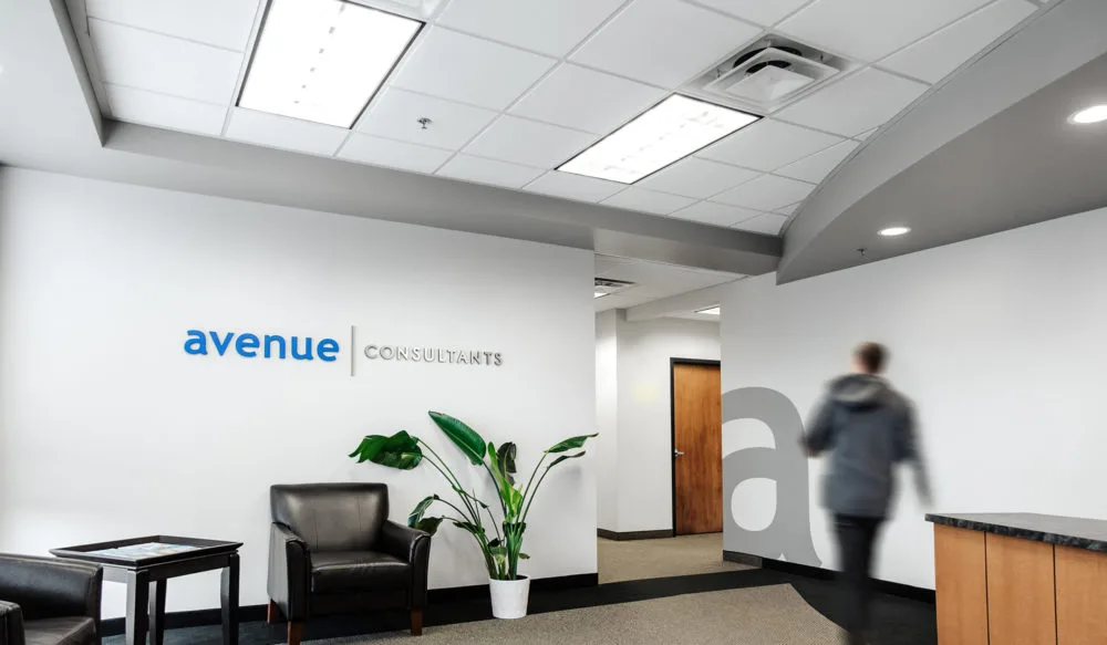 Avenue Consultants’ office lobby with a colleague walking past